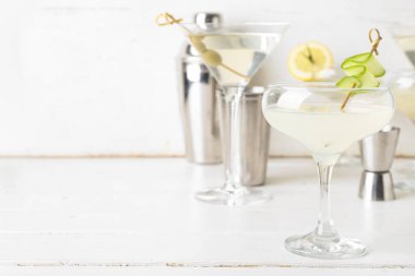 Lezzetli bir kadeh martini, beyaz ahşap masada şıngırtı ve sallama.