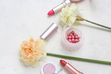 Beyaz arka planda farklı kozmetik ürünleri olan güzel nergisler.