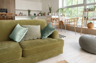 Işıl ışıl yeşil kanepeli açık mutfak ve puf.