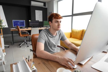 Ofiste bilgisayarla çalışan erkek programcı