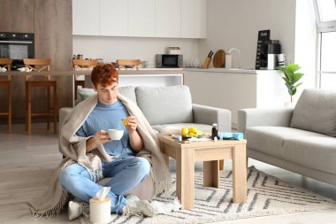 Evde limonlu çay içen genç bir adam.