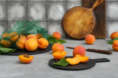 Gri masadaki kayısılarla dolu tahtalar ve ip torbaları.