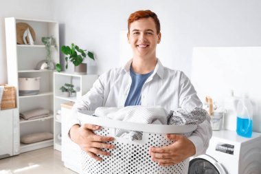 Çamaşır sepetli genç adam.