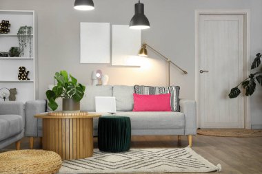 Gri kanepeli, parlak lambalı şık bir oturma odası.