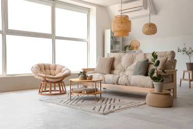 Koltuğu, koltuğu ve masası olan bir oturma odası.