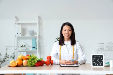 Masada çalışan Asyalı kadın beslenme uzmanı.