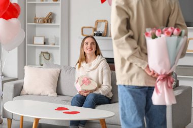 Genç adam sevgililer günü için sevgilisini bir buket çiçekle karşılıyor.