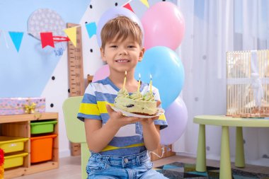 Evde doğum gününü kutlayan tatlı küçük bir çocuk.