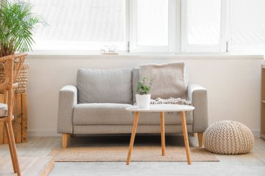 Oturma odasının içinde kanepe, masa ve puf