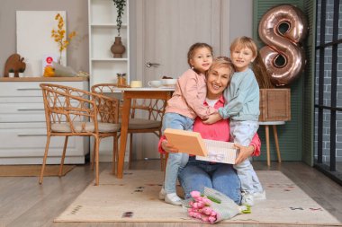Küçük çocuklar ve büyükanneleri mutfakta sarılıyorlar. Uluslararası Kadınlar Günü