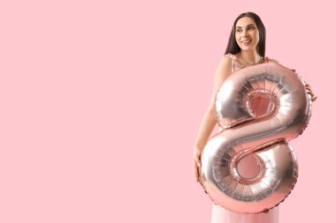 Young woman with balloon in shape of figure 8 on pink background. International Women's Day