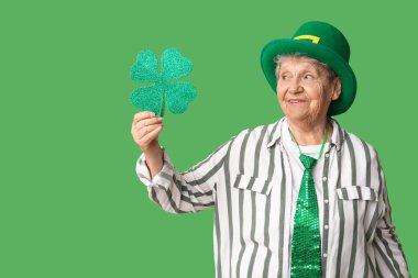 Yeşil arka planda yonca olan cüce şapkalı yaşlı kadın. Aziz Patrick Günü kutlaması