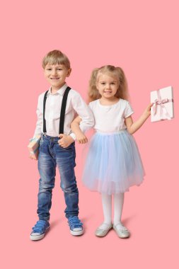 Pembe arka planda hediye kutusu olan şirin çocuklar. Uluslararası Kadınlar Günü