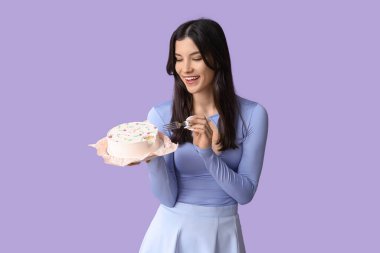 Leylak arka planında tatlı bento pastası olan güzel genç bir kadın. Uluslararası Kadınlar Günü