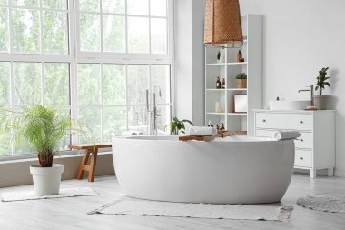 Küveti, raf ünitesi ve penceresi olan şık bir banyo.