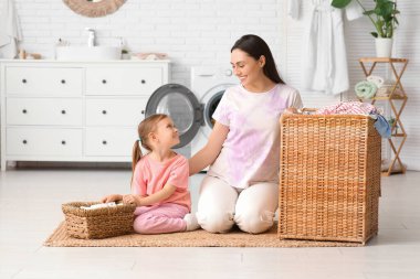 Genç anne, kızı ve sepeti evde.