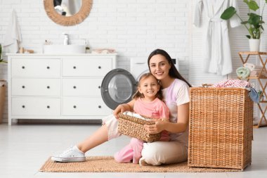 Genç anne, kızı ve sepeti evde.