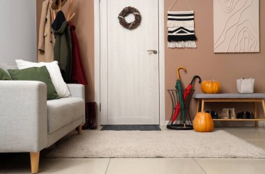 Koridorun içinde kapı, askılık ve kanepe var.