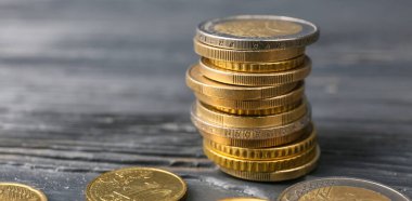 Koyu ahşap arka planda altın paralar, yakın plan