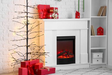 İçinde şömine, Noel ağacı ve hediye kutuları olan şenlikli bir oturma odası.