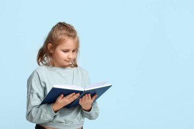 Little girl reading book on  blue background