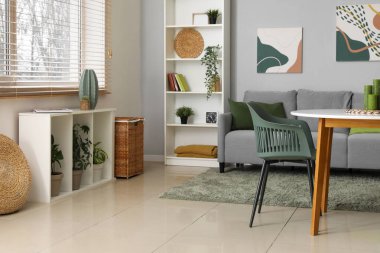 Gri kanepesi, masası ve sandalyeleri olan şık bir oturma odası.