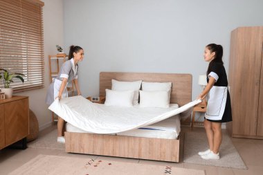 Genç oda hizmetçileri yatak odasında yatıyorlar.