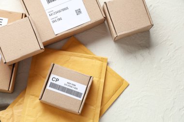 Beyaz masa üzerinde etiket ve zarflar olan karton paketler