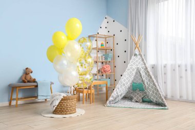 Çocuk odasının içinde bir sürü balon ve oyun çadırı.