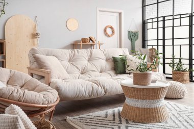 Sehpanın üzerinde bambu sapları ve beyaz kanepeyle aydınlık oturma odasının içinde.