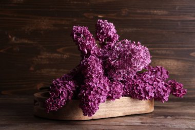 Ahşap arka planda çiçek açan bir tepsi.