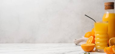 Açık arkaplanda bir şişe taze portakal suyu ve metin için yer var.