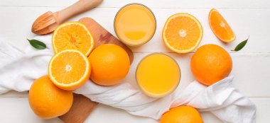 Beyaz ahşap arka planda taze portakal suyu ve meyveli kompozisyon.