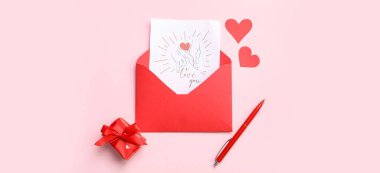 İçinde tebrik kartı, hediye kutusu ve pembe arka planda kağıt kalpler olan bir zarf. Sevgililer Günü kutlaması