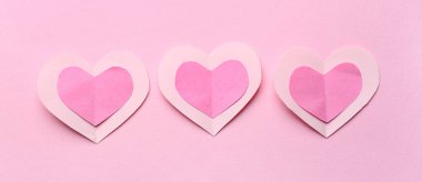 Paper hearts on pink background. Valentine's Day celebration