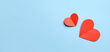 Açık mavi arkaplanda kırmızı kağıt kalpler ve metin için boşluk. Sevgililer Günü kutlaması