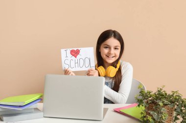 Küçük kız elinde bej arka plandaki masada 