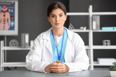 Kadın doktor ofiste hastayla görüntülü sohbet ediyor.