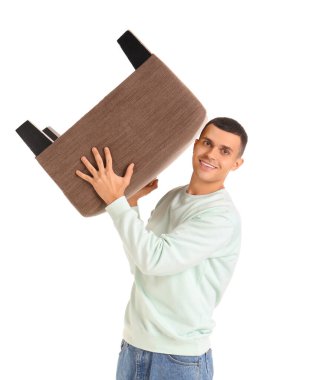 Genç adam beyaz arka planda pouf taşıyor.