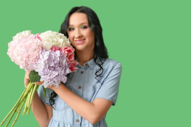 Yeşil arka planda ortanca çiçekleri olan güzel bir genç kadın. Uluslararası Kadınlar Günü