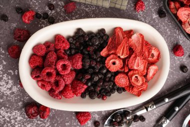 Gri arka planda lezzetli dondurulmuş meyveli kase.