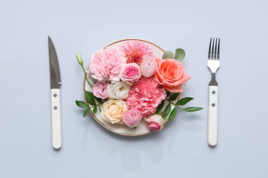 Gri arkaplanda güzel çiçek kompozisyonu olan şık masa ayarları