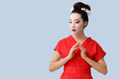 Beautiful young geisha on light background clipart