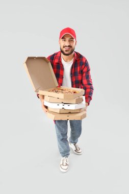 Gri arka planda pizza kutuları olan erkek kurye.