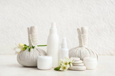 Kozmetik ürünler, spa aksesuarları ve açık arkaplanda güzel çiçekler.