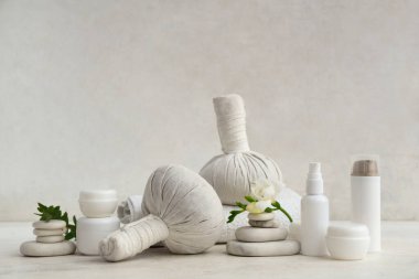 Farklı kozmetik ürünleri, spa taşları ve temiz havlu içeren kompozisyon