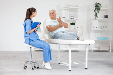 Glikoz sensörü olan diyabetik olgun bir adam kliniğe gelen doktoru ziyaret ediyor.