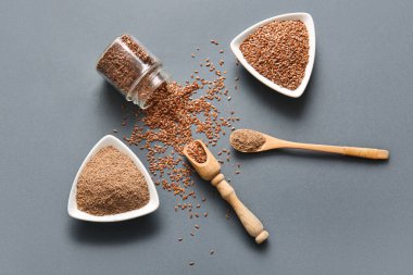 Gri arka planda keten tohumu ve un dolu kaseler