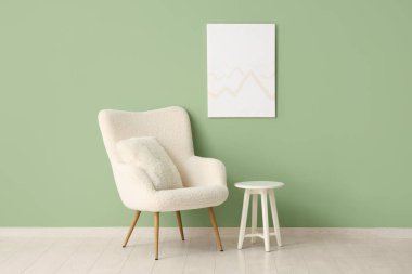 Beyaz koltuklu, kahve masalı ve yeşil duvarlı şık bir oturma odası.