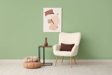 Beyaz koltuklu, kahve masalı ve yeşil duvarlı şık bir oturma odası.